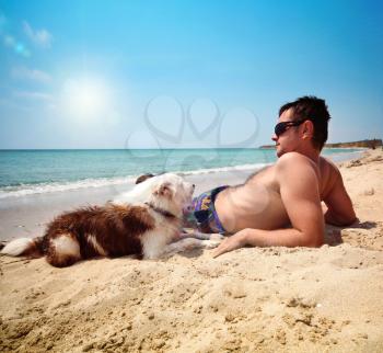 men with dog on a beach