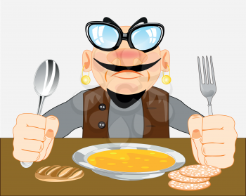 Man with fork and spoon in hand sits with meal at the table