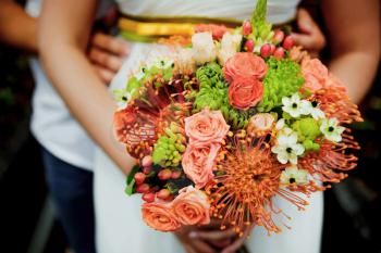 Wedding bouquet held by bride and groom. Shallow depth of field