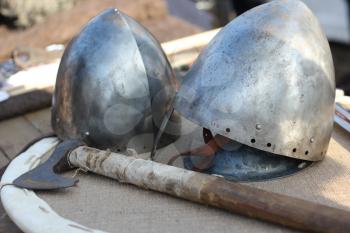 Two knightly metal helmet and ax close-up