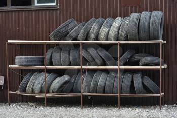 Old tires stacked on the rack in the repair shop.