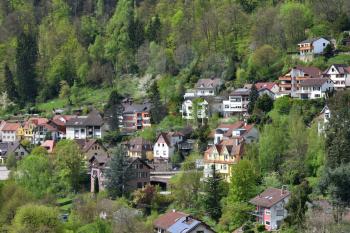 Cute village in Germany on a hillside, apartment buildings on the background of the forest