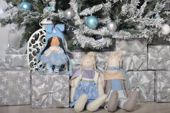 Stuffed, cute toys hare and doll, stand as a gift under the Christmas tree