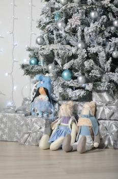 Stuffed, cute toys hare and doll, stand as a gift under the Christmas tree
