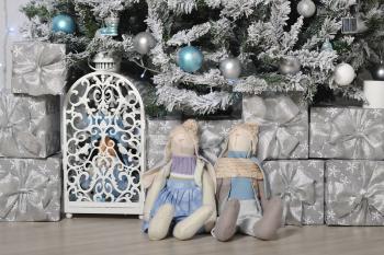 Soft, cute toy hares sit as a gift under the Christmas tree