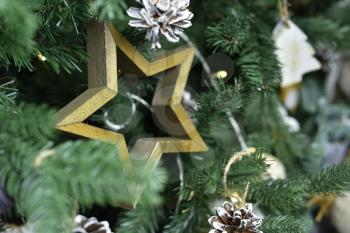 Beautiful wooden star decoration hanging on a Christmas tree