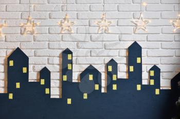 Decorations of the children's room for the New Year or Christmas, the silhouette of the city on a background of a white brick wall