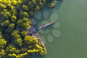 Trees and wooden bridge by the lake. Photo in Suzhou, China.