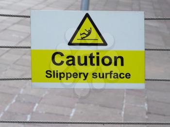 caution slippery surface sign on riverside marina