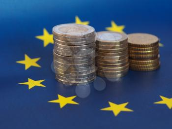 Euro coins (EUR), currency of European Union over flag of Europe