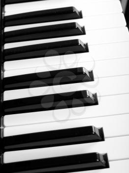Detail of black and white keys on music keyboard - over black background