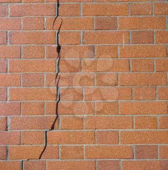 cracked brick wall caused by earthquake or foundation structural failure