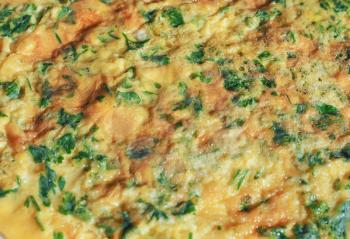 Omelette with beaten eggs fried with parsley and cilantro herbs in a dish