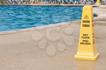 Royalty Free Photo of a Yellow Caution Sign Next to a Pool