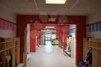 A red empty school hallway with kids hand-prints on the walls