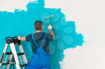 Male painter in uniform working indoors�