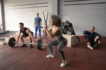 Sporty people doing exercises in gym�