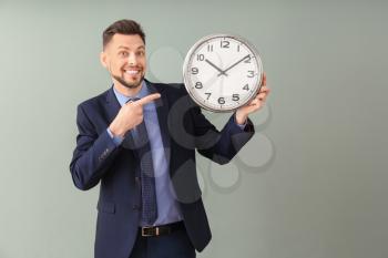 Businessman with clock on color background. Time management concept�