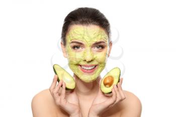Beautiful young woman with facial mask and fresh avocado on white background�