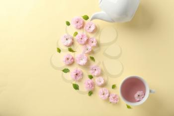 Composition with cup and blossoming flowers on color background�
