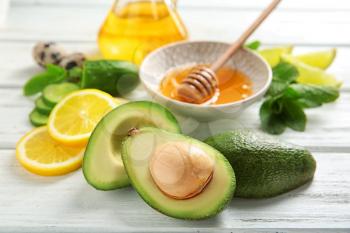 Avocado with ingredients for natural homemade cosmetics on wooden table�