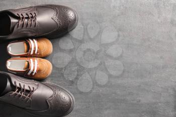 Big and small shoes on grey background. Father's day celebration�