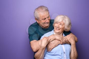 Happy senior couple on color background�
