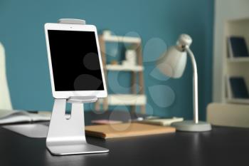 Tablet PC with holder on table in office�