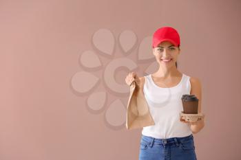 Young woman with paper bag and cups of coffee on color background. Food delivery service�