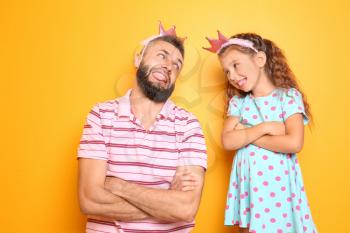 Funny portrait of father and his little daughter on color background�