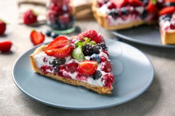 Plate with piece of delicious berry pie on table�