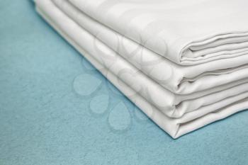 Stack of clean bed sheets on color background, closeup�