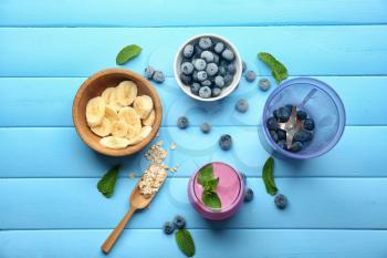 Composition with tasty blueberry smoothie on color wooden background�