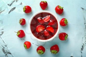 Bowl with delicious strawberry jam on light table�