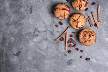 Tasty cranberry muffins on grey  table�
