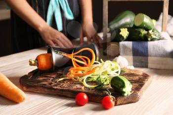Fresh zucchini and carrot spaghetti with spiral grater on wooden table�