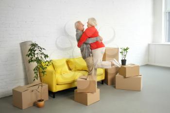 Happy mature couple with boxes after moving into new house�