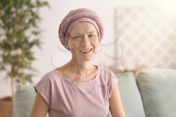 Happy woman after chemotherapy  sitting on sofa at home�