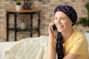 Woman after chemotherapy talking on mobile phone at home�
