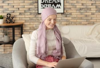 Woman after chemotherapy using laptop at home�