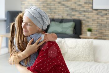 Woman after chemotherapy hugging her daughter at home�