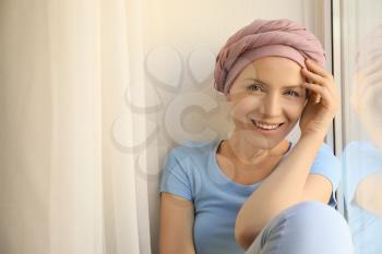 Woman after chemotherapy near window at home�