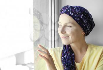 Woman after chemotherapy near window at home�