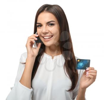 Young woman with credit card talking on mobile phone against white background. Online shopping�