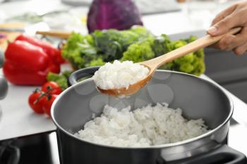 Woman cooking rice in kitchen, closeup�