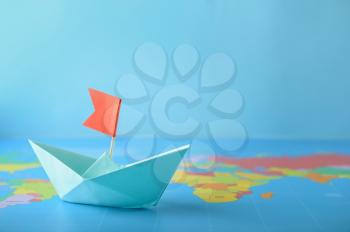 Origami boat on world map. Travel concept�