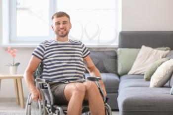 Happy young man in wheelchair at home�