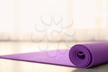 Purple yoga mat on floor indoors�