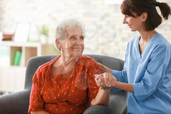 Young nurse visiting elderly woman at home�