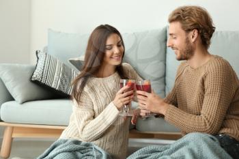 Couple drinking delicious mulled wine at home�